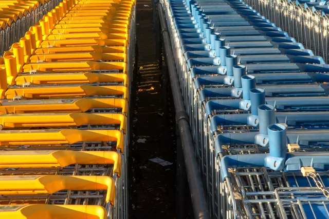 Bright yellow and blue shopping carts arranged in orderly rows outdoors. Choosing A/B testing tools for UK ecommerce stores