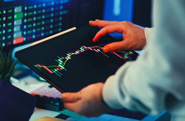 A close-up of a person using a tablet to analyze stock market trends and charts indoors. The conversion provider shortlist is empty, and here is what would fill it